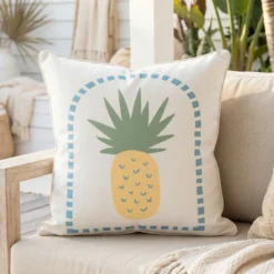 Tropica cushion with pineapple motif and dotted blue border on outdoor sofa.