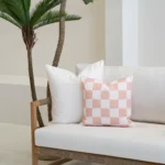 Tropica pink cushions with gingham check and plain white cushions on sofa.