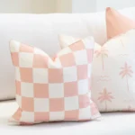 Close-up of Tropica pink cushions with gingham pattern and palm print design.