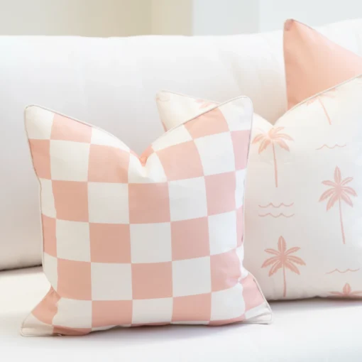 Close-up of Tropica pink cushions with gingham pattern and palm print design.