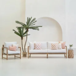 Tropica pink cushions styled on sofa and chair in outdoor setting.