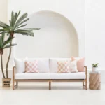 Tropica pink cushions arranged on outdoor sofa with soft blush tones.