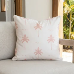 Tropica pink cushion with palm tree pattern on outdoor lounge chair.