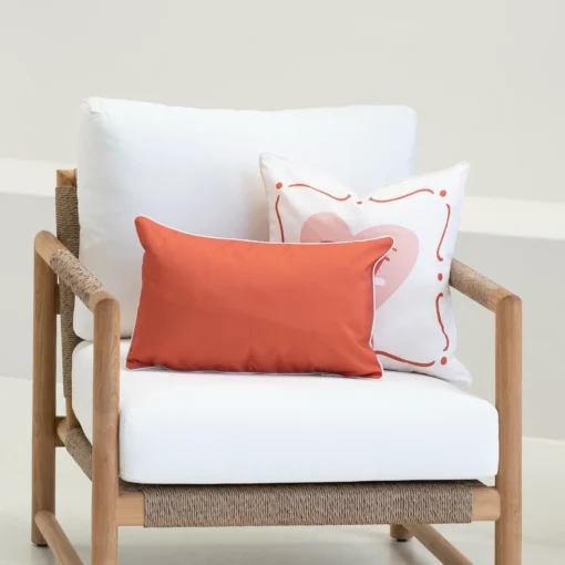 Tropica red cushions with solid rectangular cushion and heart motif cushion on armchair.