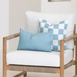 Tropica aqua cushions styled on armchair with check pattern and solid design.
