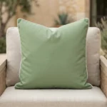 Tropica green cushion with white piping on outdoor armchair.
