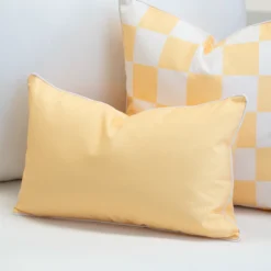 Tropica yellow cushion paired with check pattern cushion on lounge chair.