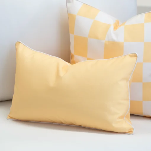 Tropica yellow cushion paired with check pattern cushion on lounge chair.