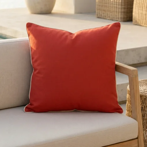 Tropica red cushion with white piping on outdoor armchair.