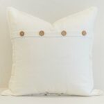 White linen button cushion cover with a crisp, fresh finish and natural wooden button detail for subtle texture.