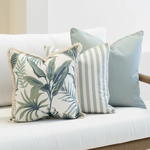 Close-up of Wildgrove Frond cushions with leafy pattern and striped design.