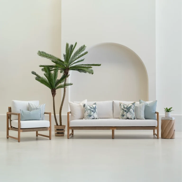 Tropica red cushions arranged on outdoor sofa and armchair with check patterns.