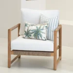 Wildgrove Palm cushions arranged on armchair with palm print and stripe pattern.