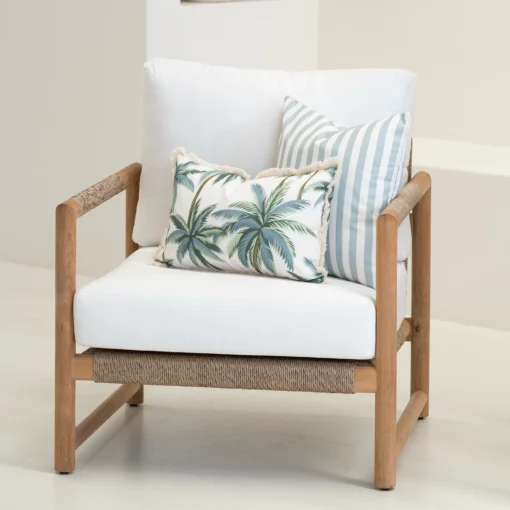 Wildgrove Palm cushions arranged on armchair with palm print and stripe pattern.