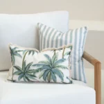 Wildgrove Palm cushions with palm print and blue striped cushions on sofa.