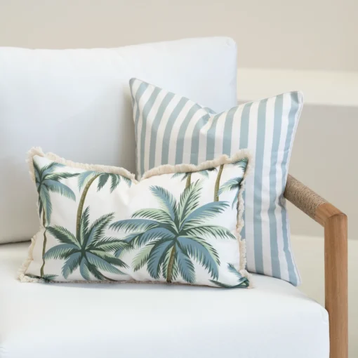 Wildgrove Palm cushions with palm print and blue striped cushions on sofa.