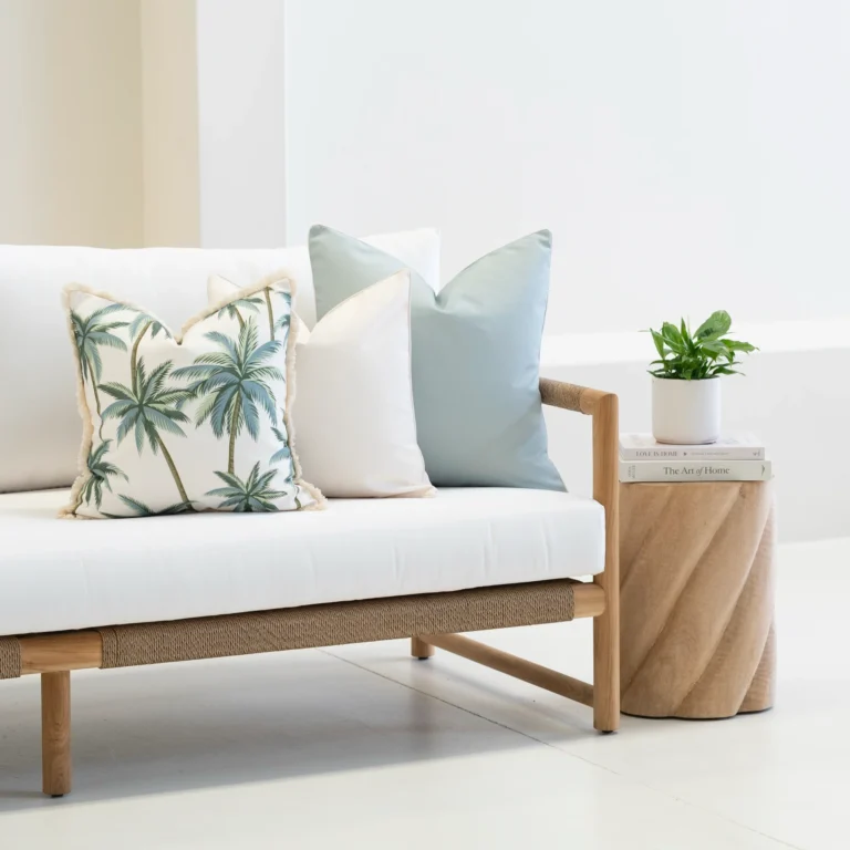 Wildgrove Palm cushions arranged on sofa with palm print and soft blue tones.