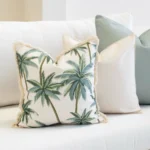 Wildgrove Palm cushion with green palm print and fringed edges on sofa.