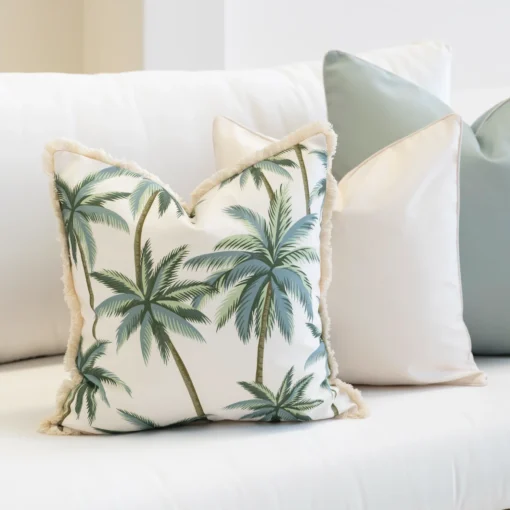 Wildgrove Palm cushion with green palm print and fringed edges on sofa.