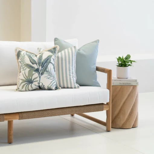 Wildgrove Palm cushions styled on sofa with striped and botanical patterns.