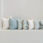 Wildgrove Palm cushions in soft blue and white arranged along bench.