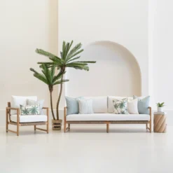 Wildgrove Palm cushions styled on outdoor sofa and chair with palm patterns.