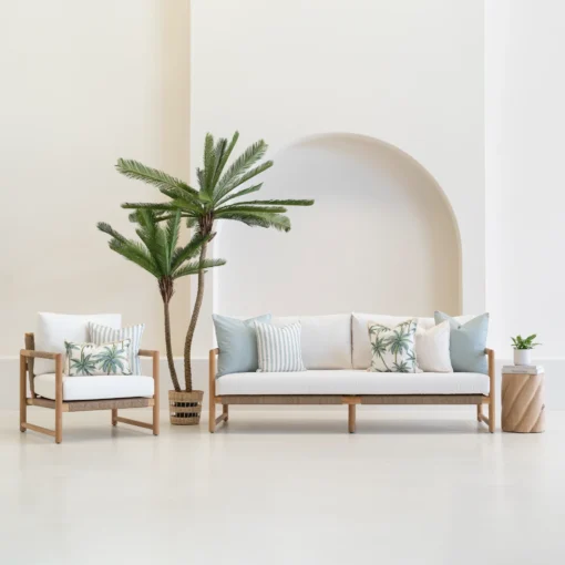 Wildgrove Palm cushions styled on outdoor sofa and chair with palm patterns.