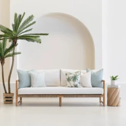 Wildgrove Palm cushions with soft blue tones and palm prints on sofa.