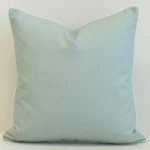 Wildgrove seafoam cushion in soft blue-green tone with white piping.