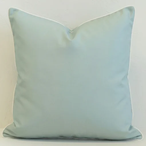 Wildgrove seafoam cushion in soft blue-green tone with white piping.